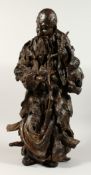 A VERY GOOD LARGE CHINESE ROOTWOOD CARVING OF AN IMMORTAL holding a peach. 27ins high.