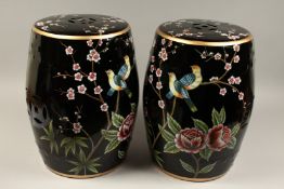 A PAIR OF CHINESE BLACK PORCELAIN BARREL SEATS flowers and birds. 18ins high.