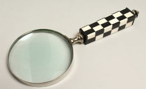 A MAGNIFYING GLASS WITH CHECKERED HANDLE.