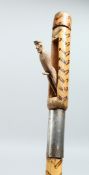 AN EROTIC BAMBOO WALKING CANE, the handle with a pop-out sailor - the shaft with burnt decoration.