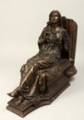 A CLASSICAL BRONZE OF A SEATED YOUNG LADY holding a rose, beside a column. 18ins long.