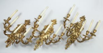 A SET OF THREE, FIVE BRANCH WALL APPLIQUES each with urn finial, female mask back plates and