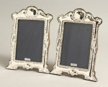 A PAIR OF SILVER SERPENTINE TOP PHOTOGRAPH FRAMES. 8ins x 6.5ins.