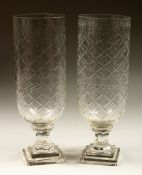 A PAIR OF STAR CUT GLASS STORM LAMPS on stepped bases. 13ins high.