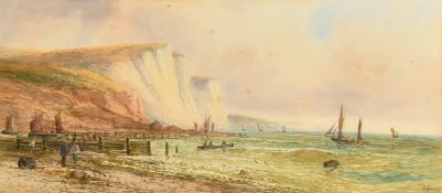 E. Lewes (circa 1900) A busy beach scene along the coast near white cliffs with figures and boats on