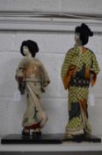Two Japanese cloth and porcelain models of a Samurai and a Geisha.