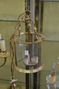 A brass and glass circular hall lantern.