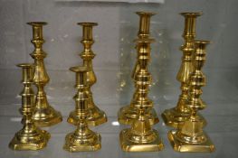 Four pairs of brass candlesticks.