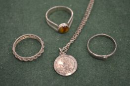 A silver chain with a St Christopher and three rings.