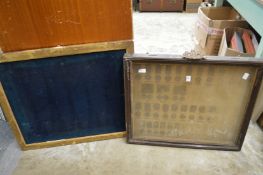 A display case for medals and a gilt framed board.