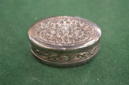 An embossed silver pill box.