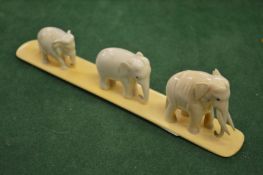 A carved group of three elephants.