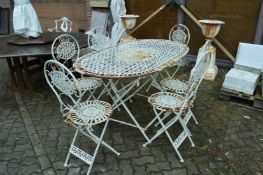A white painted oval garden table with six matching folding chairs.
