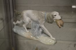 Lladro model of a setter holding a bird in its mouth.