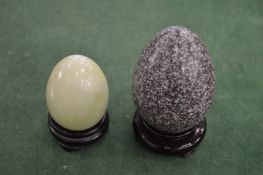 Two decorative hardstone eggs on stands.