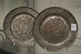 A pair of embossed metal plates depicting biblical scenes.