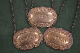 A set of three silver decanter labels.