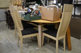 A modern extending dining table and eight high back chairs.