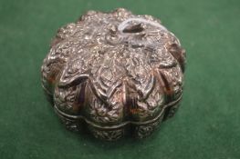 An embossed white metal box and cover modelled as a pumpkin.