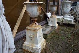 A good pair of painted cast iron pedestal urns (Note: tops are fixed to bases).