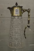 A cut glass claret jug with plated mounts.