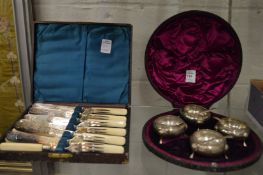 A cased set of four silver salts with spoons together with a cased set of plated dessert knives