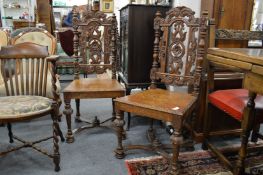 A pair of carved oak dining chairs.