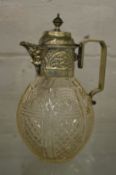 A cut glass claret jug with plated mounts.