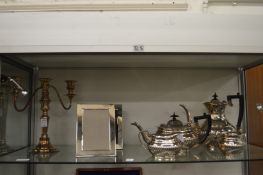 A plated four-piece tea service, a pair of picture frames and a candelabra.