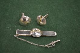 A silver tie clip and matching cufflinks.