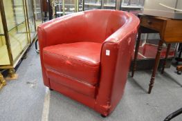 A red leather cloth upholstered armchair.