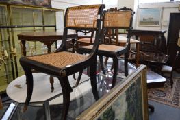 A pair of Regency ebonised and canework dining chairs.