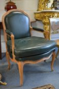 A good pair of beech framed open armchairs with green leather upholstered backs, arms and seats.