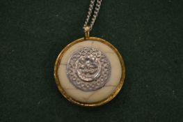 A silver necklace and decorative pendant.