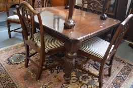 A mahogany extending dining table with two leaves (lacking winding handle).