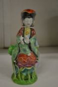 A small Chinese figure of a woman.