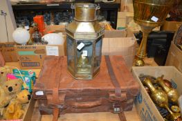 An old brass lantern and an old leather suitcase.