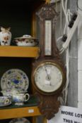An oak cased barometer and thermometer.