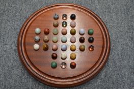 A solitaire board and various marbles.