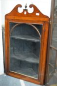 A mahogany hanging corner cabinet.