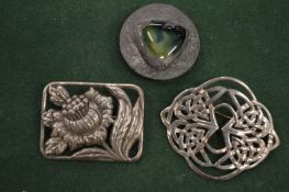 Decorative silver and other brooches.