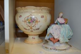 A decorative figurine and a jardiniere.