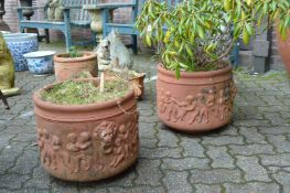 A pair of classical style terracotta circular garden planters.
