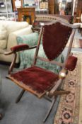 A Victorian mahogany and velvet upholstered folding armchair.
