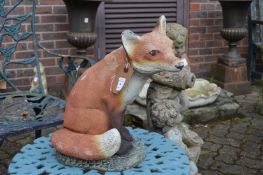 A painted composite model of a seated fox.