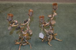 A pair of decorative figural cast metal candelabra.