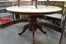 A modern circular marble topped pedestal dining table.