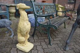 A pair of composite garden ornaments modelled as seated greyhounds.