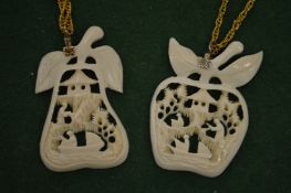 Two carved pendants with chains.