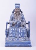 A LARGE CHINESE POWDER BLUE GLAZE POTTERY SEATED FIGURE of a god, the figure seated upon a throne